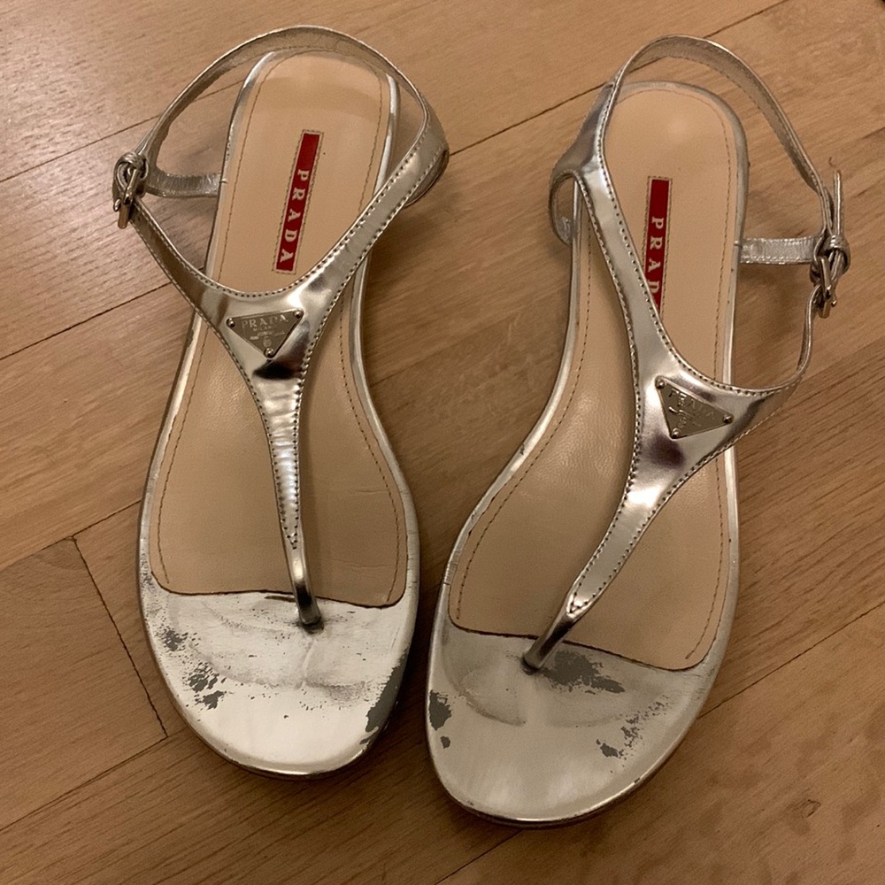 Prada silver low heal sandals. There is wear on the toe bed,